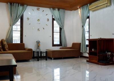 Modern living room with wooden ceiling, marble floor, and curtains