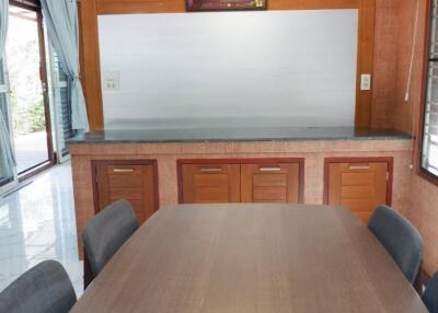 Dining area with wooden table and chairs, and wooden cabinetry