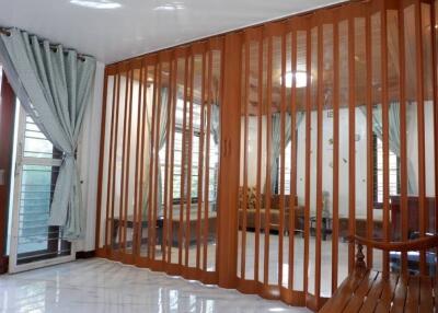 Spacious living room with wooden slat room divider