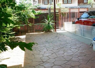 Carport with stone flooring and wooden pergola