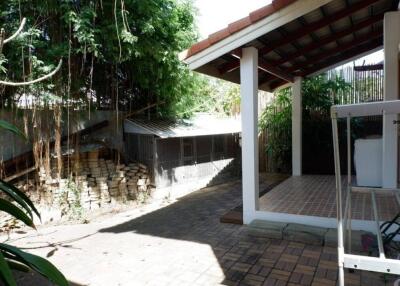 Outdoor covered patio with tiled floor and garden view