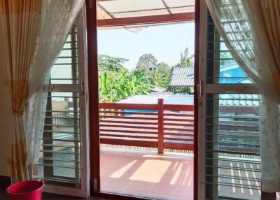 Living area with large windows and curtains opening to a balcony