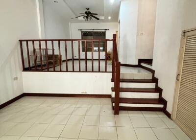 spacious living area with tile flooring and wooden staircase