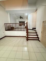 spacious living area with tile flooring and wooden staircase