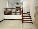 spacious living area with tile flooring and wooden staircase