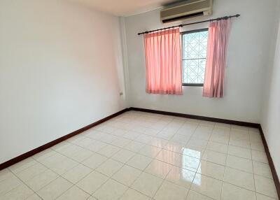 Empty bedroom with tiled floor and window with pink curtains