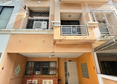 Front view of a multi-story townhouse with parking area