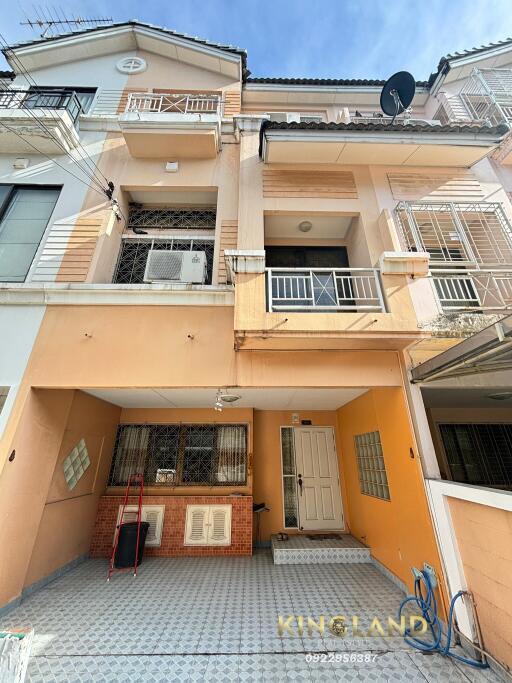 Front view of a multi-story townhouse with parking area