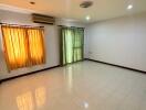 Spacious living room with tiled flooring and large windows