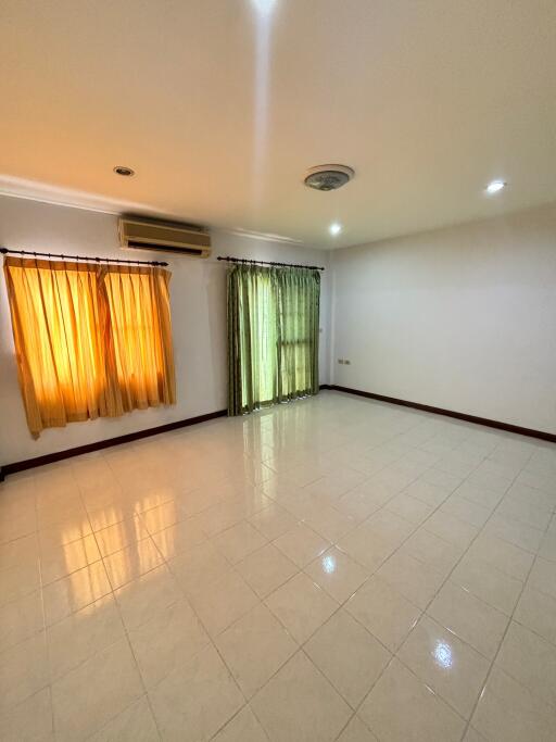 Spacious living room with tiled flooring and large windows