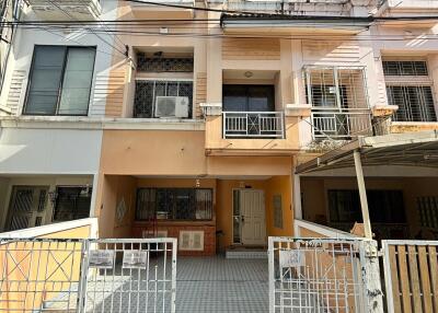 Facade of multi-story residential building with gates and driveways