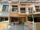 Facade of multi-story residential building with gates and driveways