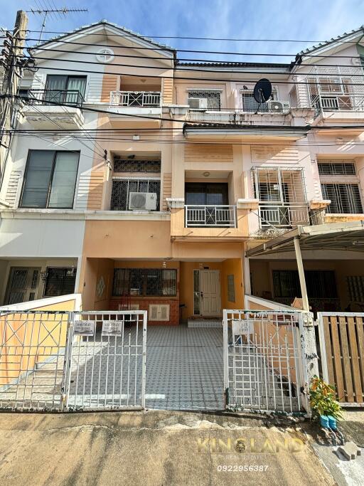 Facade of multi-story residential building with gates and driveways