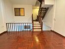 Spacious living room with wooden flooring and staircase