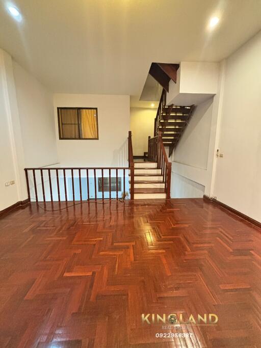 Spacious living room with wooden flooring and staircase