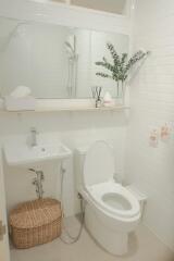 Modern bathroom with white tiles, a large mirror, and a small sink