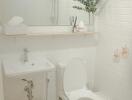 Modern bathroom with white tiles, a large mirror, and a small sink