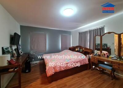 Spacious bedroom with wood flooring and large bed