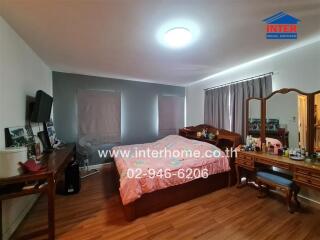 Spacious bedroom with wood flooring and large bed