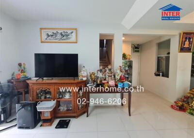 Living room with TV, wooden cabinet, and various decorations