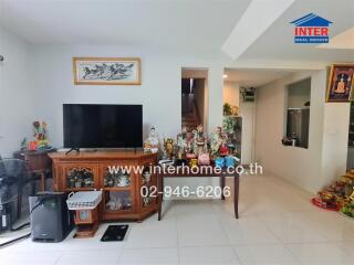 Living room with TV, wooden cabinet, and various decorations