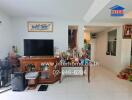 Living room with TV, wooden cabinet, and various decorations