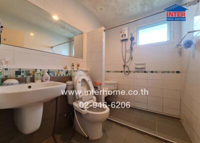 Modern bathroom with shower, toilet, sink, and mirror