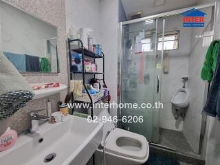 Bathroom with sink, toilet, shower, and storage rack