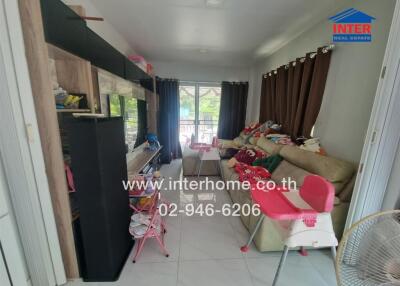 Living room with glass door, curtains, sofas, toys, and furniture