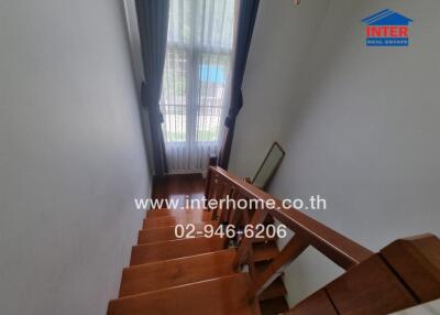 Wooden staircase with large window and blue curtains