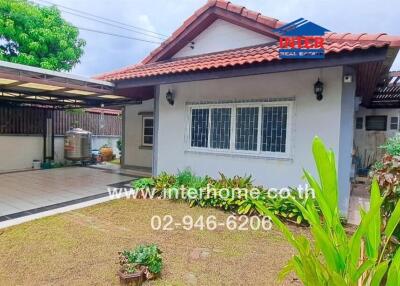 Exterior view of a house with a yard and carport