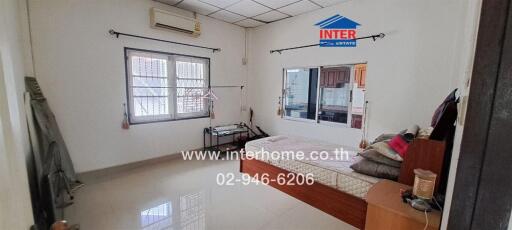 Bedroom with tiled floor, large windows, bed, and air conditioning unit