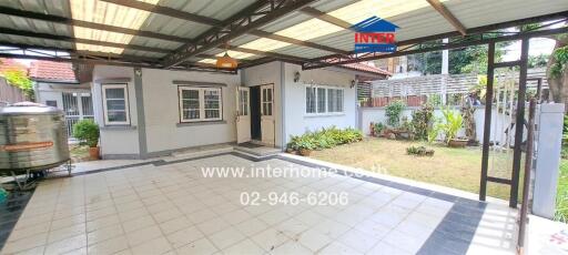 Covered outdoor area with garden and building view