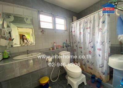 Bathroom with sink, toilet, mirror, and shower with curtain