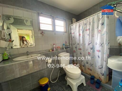 Bathroom with sink, toilet, mirror, and shower with curtain