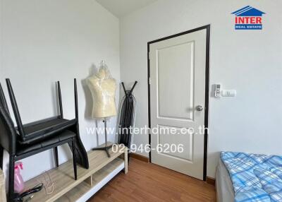 Small bedroom with furniture and a mannequin