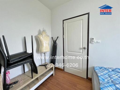 Small bedroom with furniture and a mannequin