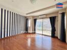 Spacious living room with striped accent wall and wooden flooring