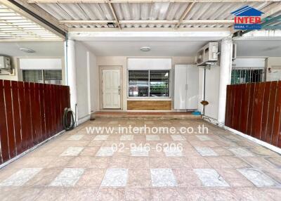 Covered carport space with tiled flooring and a white door