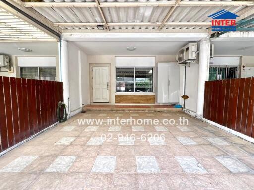 Covered carport space with tiled flooring and a white door