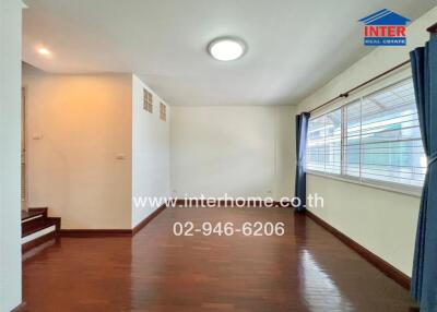 Bright and spacious living area with wooden flooring and large windows