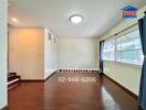 Bright and spacious living area with wooden flooring and large windows