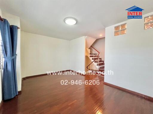 Spacious living area with wooden flooring and staircase