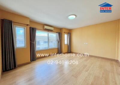 Spacious living room with wooden flooring and large windows