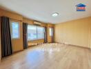 Spacious living room with wooden flooring and large windows