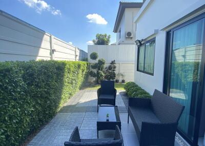 Modern outdoor patio with wicker furniture and greenery