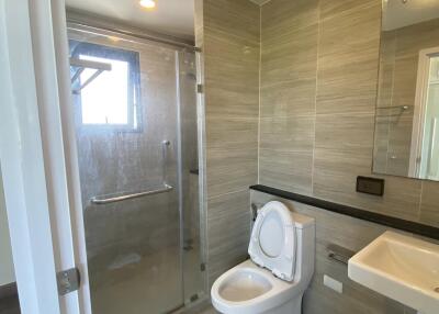 Modern bathroom with glass shower, toilet, and sink