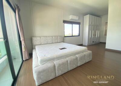 Spacious bedroom with a large bed, balcony access, and ample natural light