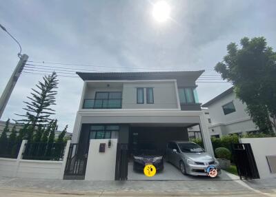 Exterior view of a modern two-story house with a driveway and two cars parked