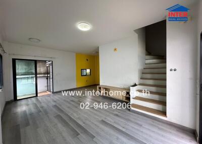 modern living room with grey laminate flooring, stairs, and sliding glass doors leading to a balcony